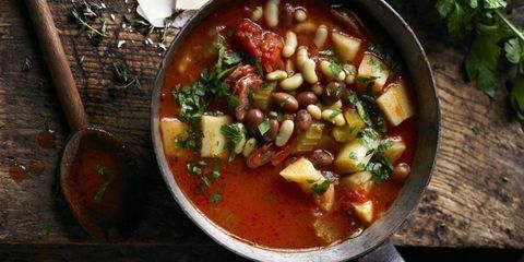 Sopa de pastinaga com salsicha italiana e tomate na panela com colher de pau ao lado