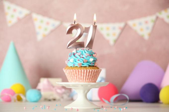 Cupcake de aniversário de 21 anos com número de velas na mesa branca
