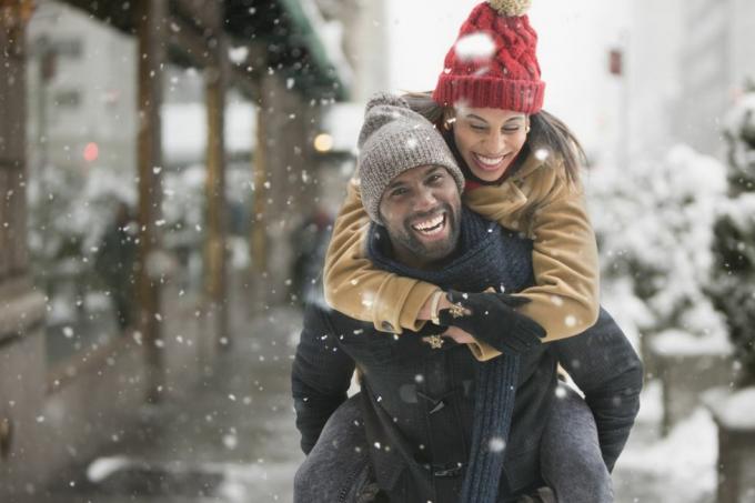 homem carregando namorada nas costas na neve