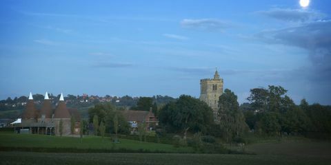 Vista de Goudhurst em Kent ao entardecer com casas de igreja e oast St Marys