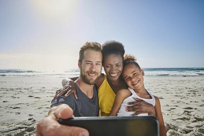 família tirando autorretrato na praia