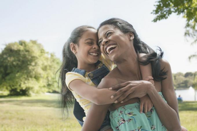 mãe hispânica e filha brincando no parque