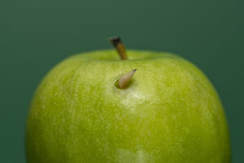 Larva saindo de uma maçã verde