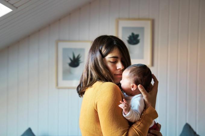vista lateral da nova mãe confortando seu recém-nascido enquanto chora, bebê se acostumando com ruídos e luzes em seus primeiros dias de vida fora do útero