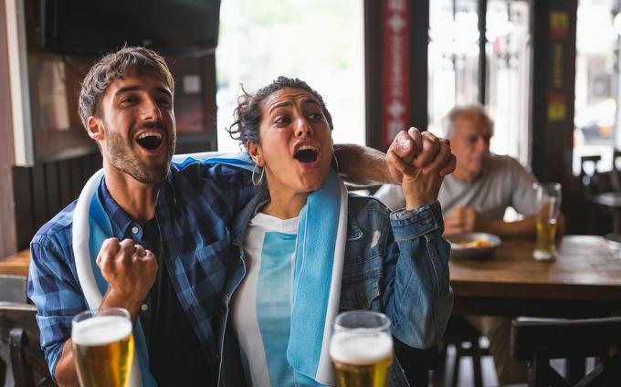 casal de ideias para um segundo encontro em um bar de esportes