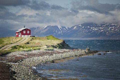 casa vermelha ao lado de um fiorde no norte da islândia