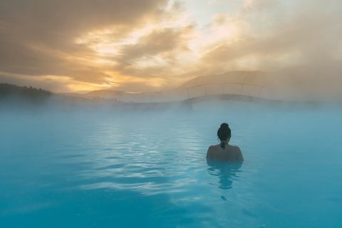 vista traseira de uma mulher em pé na lagoa azul, Islândia