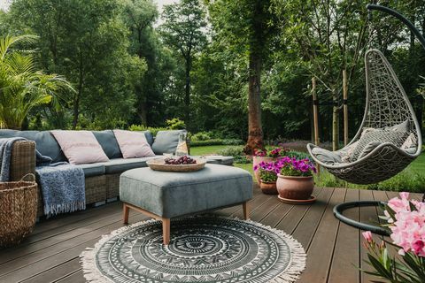 pátio do jardim decorado com sofá de vime escandinavo e mesa de centro