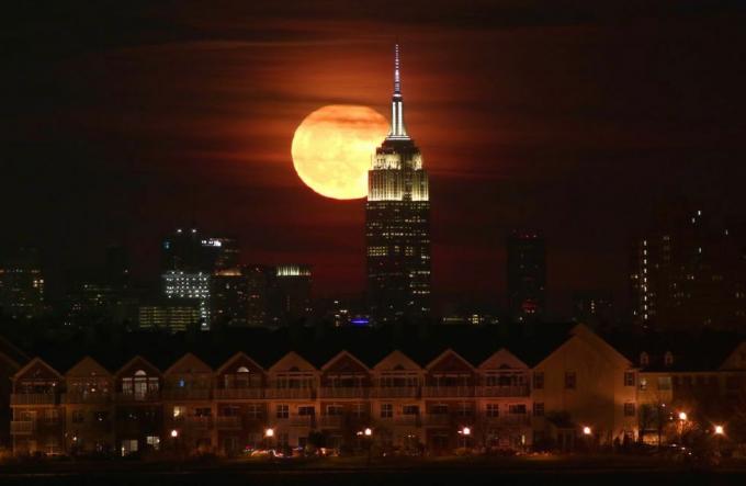 Lua cheia surge atrás do Empire State Building em Nova York