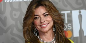 shania twain em vestido amarelo e colar de diamantes