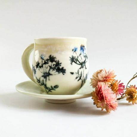 Xícara e pires de porcelana com design de flores de sebe