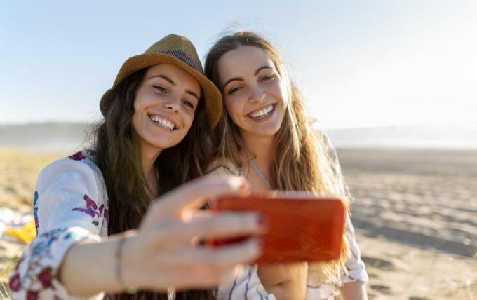 dois melhores amigos tomando selfie com smartphone na praia