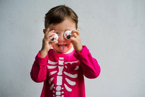 menina vestida com uma camisa de esqueleto com óculos engraçados