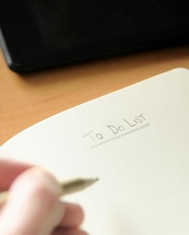 mão cortada de homem escrevendo no bloco de notas na mesa no escritório
