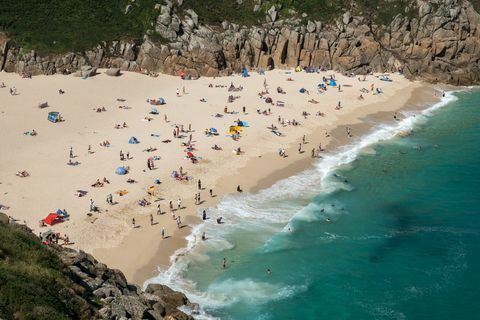 Os visitantes tomam sol na Praia de Porthcurno, perto de Penzance, em 28 de junho de 2018.