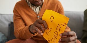 close-up da carta de abertura do homem afro-americano para o papai como presente feito à mão para o dia dos pais, copie o espaço