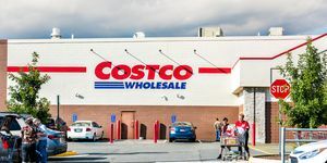 Pessoas de Fairfax com carrinhos de compras cheios de produtos de mercearia e produtos saindo da loja Costco, na Virgínia, no estacionamento