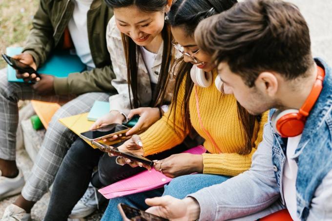 diversos jovens estudantes adolescentes se divertindo usando telefone celular na educação do campus universitário, pessoas da geração Y e conceito de mídia social