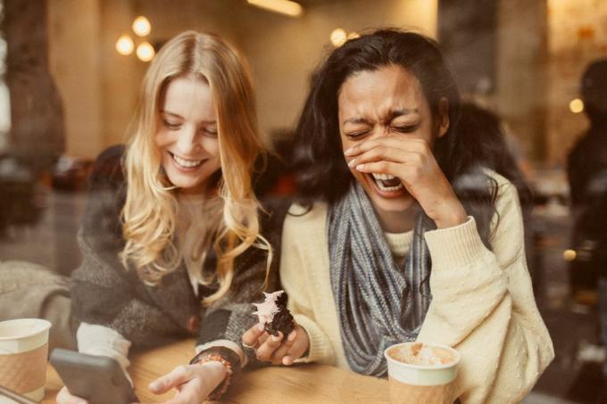 namoradas usando smartphone em coffeeshop