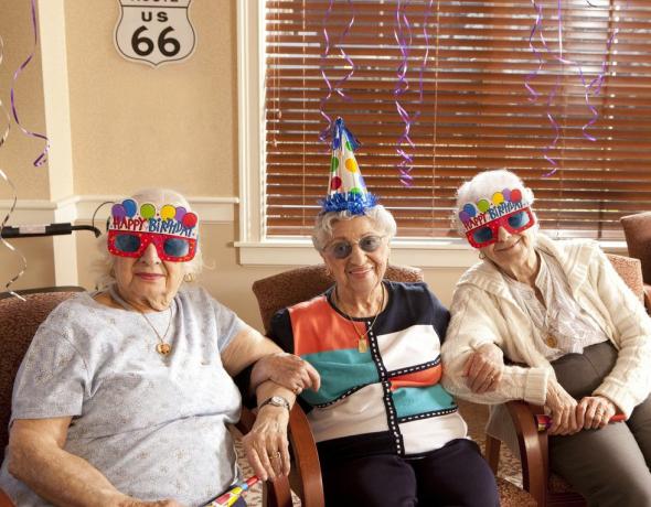 senhoras idosas com chapéus de aniversário e óculos de festa